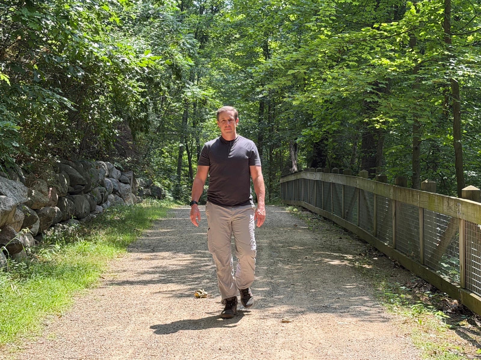 Gregg Huffman walking a wooded Michigan trail toward the camera