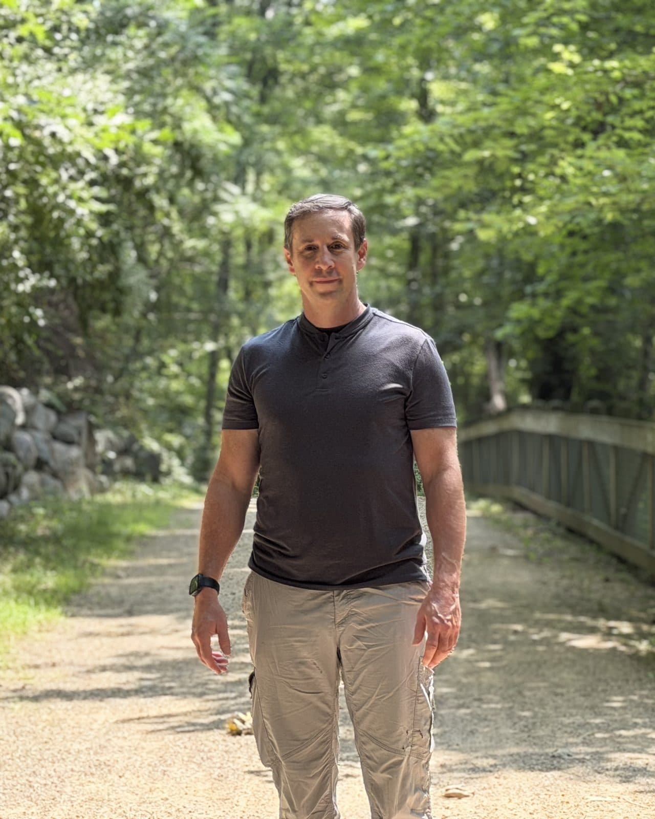 Gregg Huffman standing on a wooded Michigan trail, facing the camera